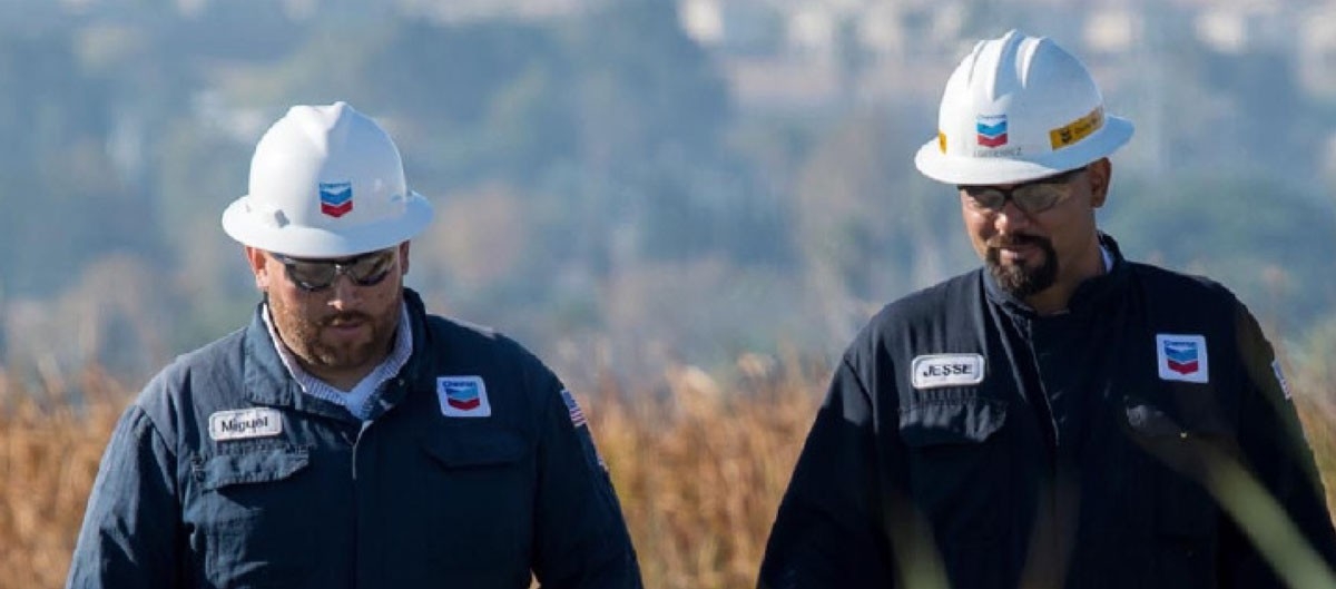 two chevron marine workers walking and smiling.