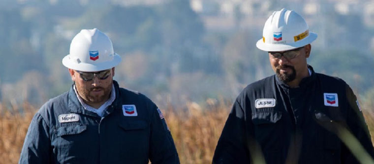 two chevron marine workers walking and smiling.